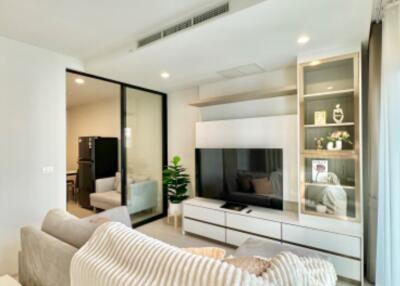 Modern living room with two gray sofas, TV, and glass divider