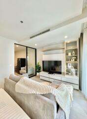 Modern living room with two gray sofas, TV, and glass divider