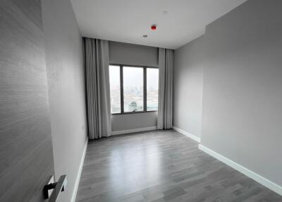 Empty bedroom with window and wooden flooring