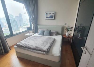 Spacious and well-lit bedroom with a scenic city view