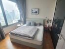 Spacious and well-lit bedroom with a scenic city view