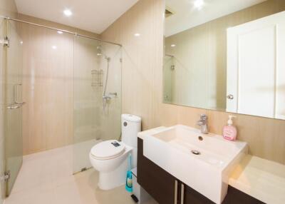 modern bathroom with glass shower enclosure, toilet, and sink