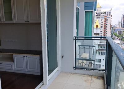 Photograph of a patio area with glass railings and view of urban surroundings