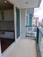 Photograph of a patio area with glass railings and view of urban surroundings