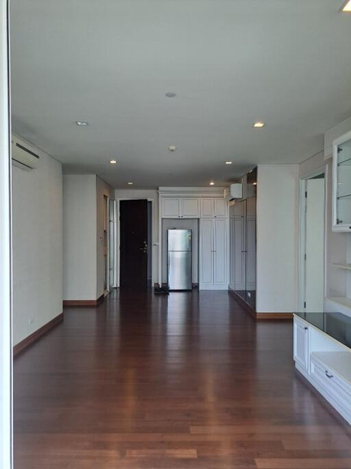 Spacious living area with hardwood floors and built-in shelves