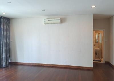 Spacious bedroom with hardwood floors and air conditioning