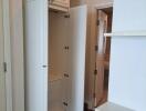 Open wardrobe with adjoining storage features in a bedroom