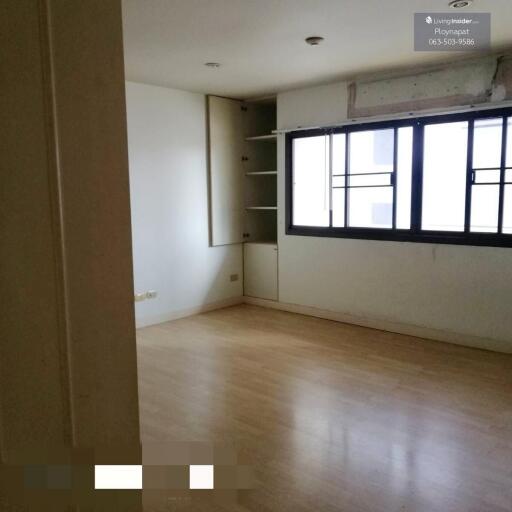 Unfurnished bedroom with large window and built-in shelves