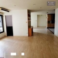 Spacious living room with wooden flooring and built-in shelving unit