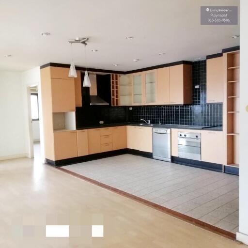 Modern kitchen with light wood cabinetry and black backsplash