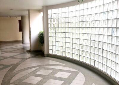 Spacious and well-lit hallway with unique glass block wall and modern design