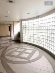 Spacious and well-lit hallway with unique glass block wall and modern design