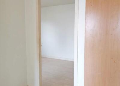 Empty room with open door and wooden panel