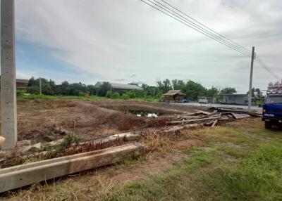 vacant lot with construction materials and a nearby structure