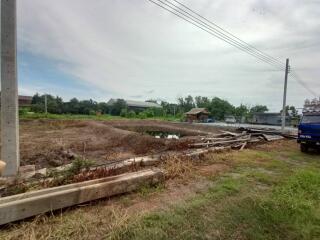 vacant lot with construction materials and a nearby structure