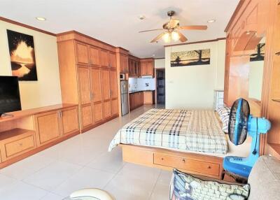 Spacious bedroom with wooden cabinetry and a bed