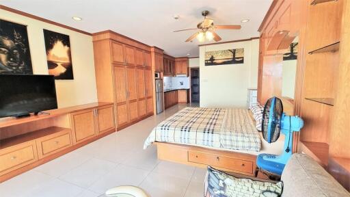 Spacious bedroom with wooden cabinetry and a bed