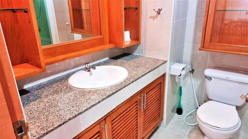 Modern bathroom with granite countertop and wooden cabinets