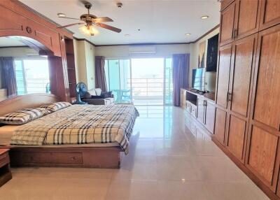 Spacious bedroom with large wooden wardrobe and balcony