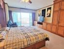 Spacious and well-lit bedroom with large bed, wooden wardrobe and balcony access