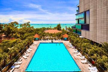 Outdoor swimming pool with lounge chairs and view of the beach