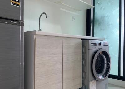 Modern laundry area with washing machine and fridge