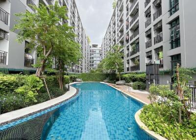 Outdoor swimming pool with surrounding modern apartment buildings