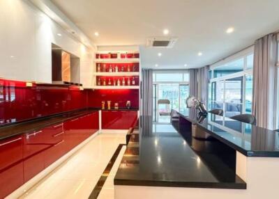 Modern kitchen with red cabinets and black countertops