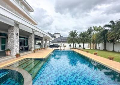 Luxurious outdoor pool area with palm trees and landscaped garden