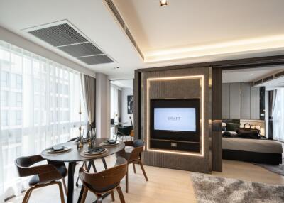 Modern living area with dining table, chairs, TV, and large windows