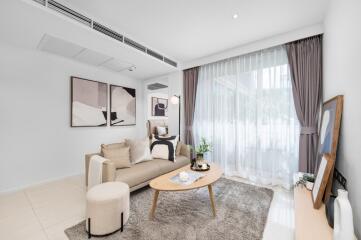 Modern living room with a cozy setup including a beige sofa, coffee table, and large window with draped curtains