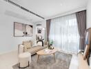 Modern living room with a cozy setup including a beige sofa, coffee table, and large window with draped curtains