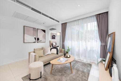 Modern living room with a cozy setup including a beige sofa, coffee table, and large window with draped curtains