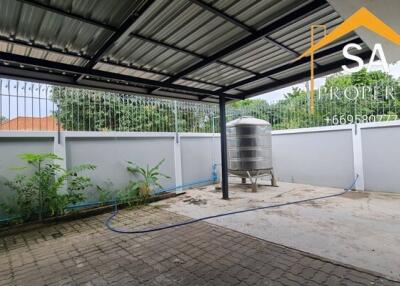 Covered outdoor area with metal roof, paved flooring, railing, and a water tank