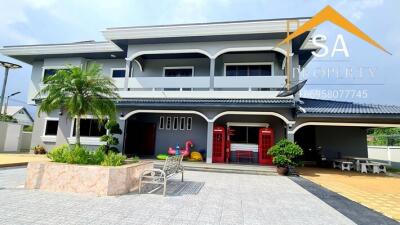 Front view of a modern two-story house with a landscaped yard