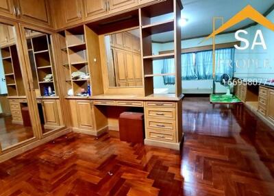 Spacious wooden closet in bedroom with large mirrors and ample storage