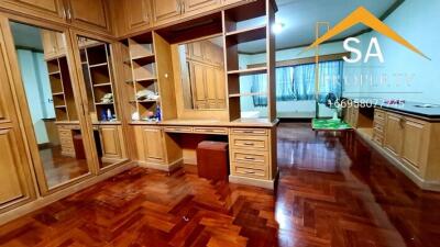 Spacious wooden closet in bedroom with large mirrors and ample storage