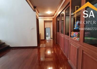 A polished wooden hallway with storage cabinets