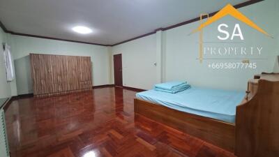 Spacious bedroom with wooden floor, bed, and wardrobe