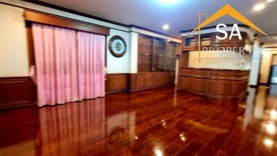 Spacious living room with wooden flooring and built-in cabinets