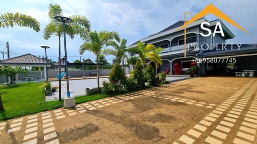 Exterior view of a property with a spacious driveway and lush garden