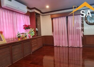 Spacious living room with wooden flooring and pink curtains