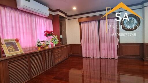 Spacious living room with wooden flooring and pink curtains