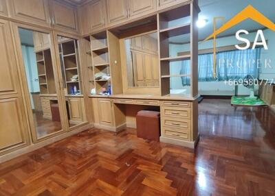 Spacious bedroom with wooden flooring and built-in wooden wardrobes.