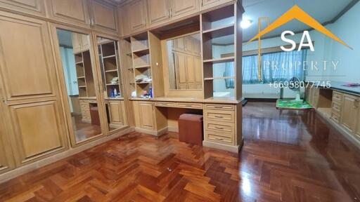 Spacious bedroom with wooden flooring and built-in wooden wardrobes.