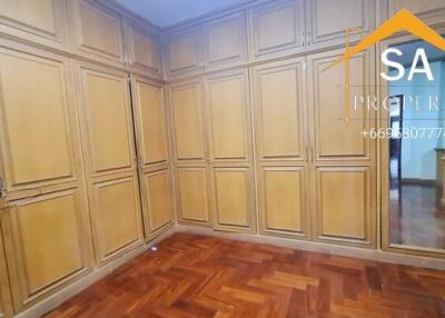 Spacious bedroom with ample wooden wardrobes and parquet flooring