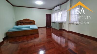 Spacious bedroom with wooden floor and air conditioning