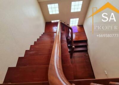 Wooden staircase with handrail and skylight windows