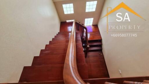 Wooden staircase with handrail and skylight windows