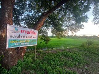 View of a plot of land with a banner, green fields, and trees